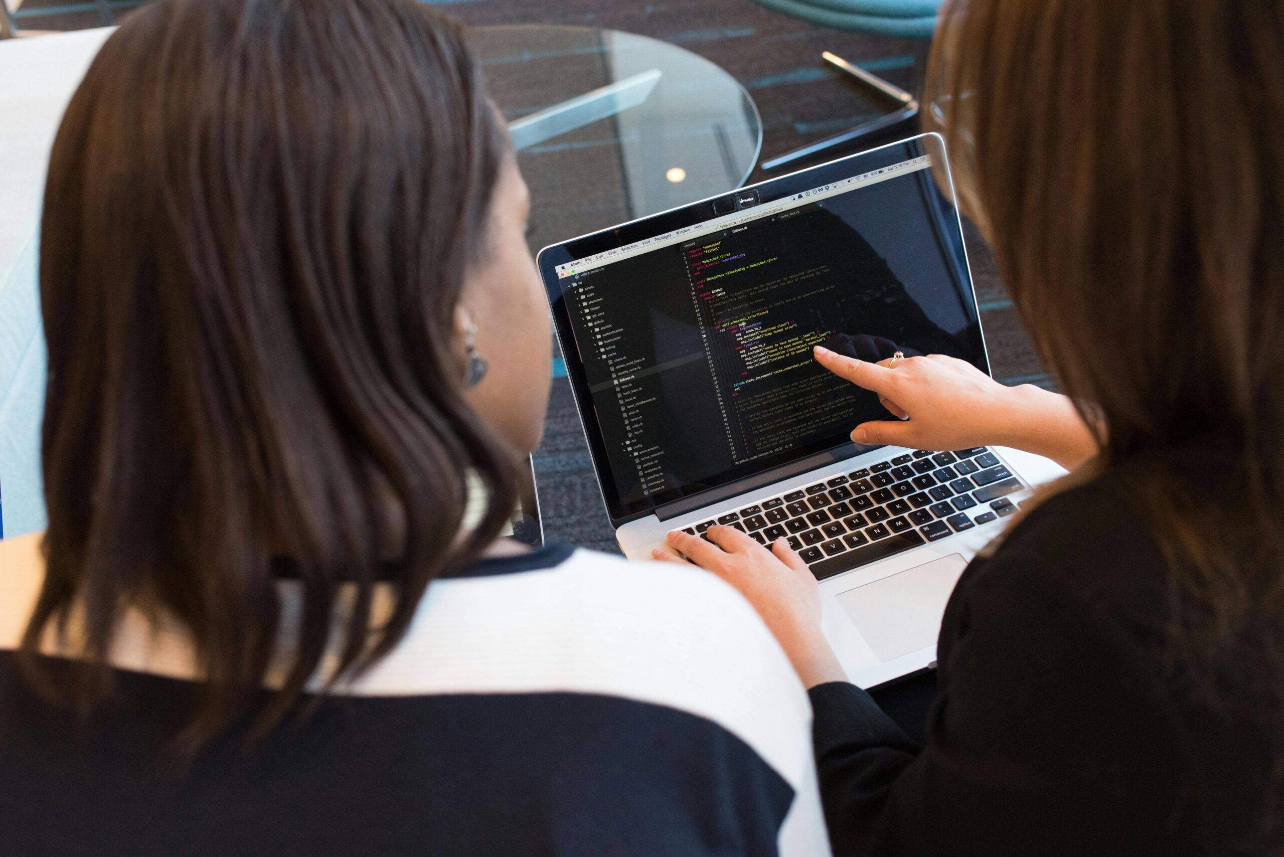 Two Procode team members viewing a laptop screen showcasing Smart Datastream technology.